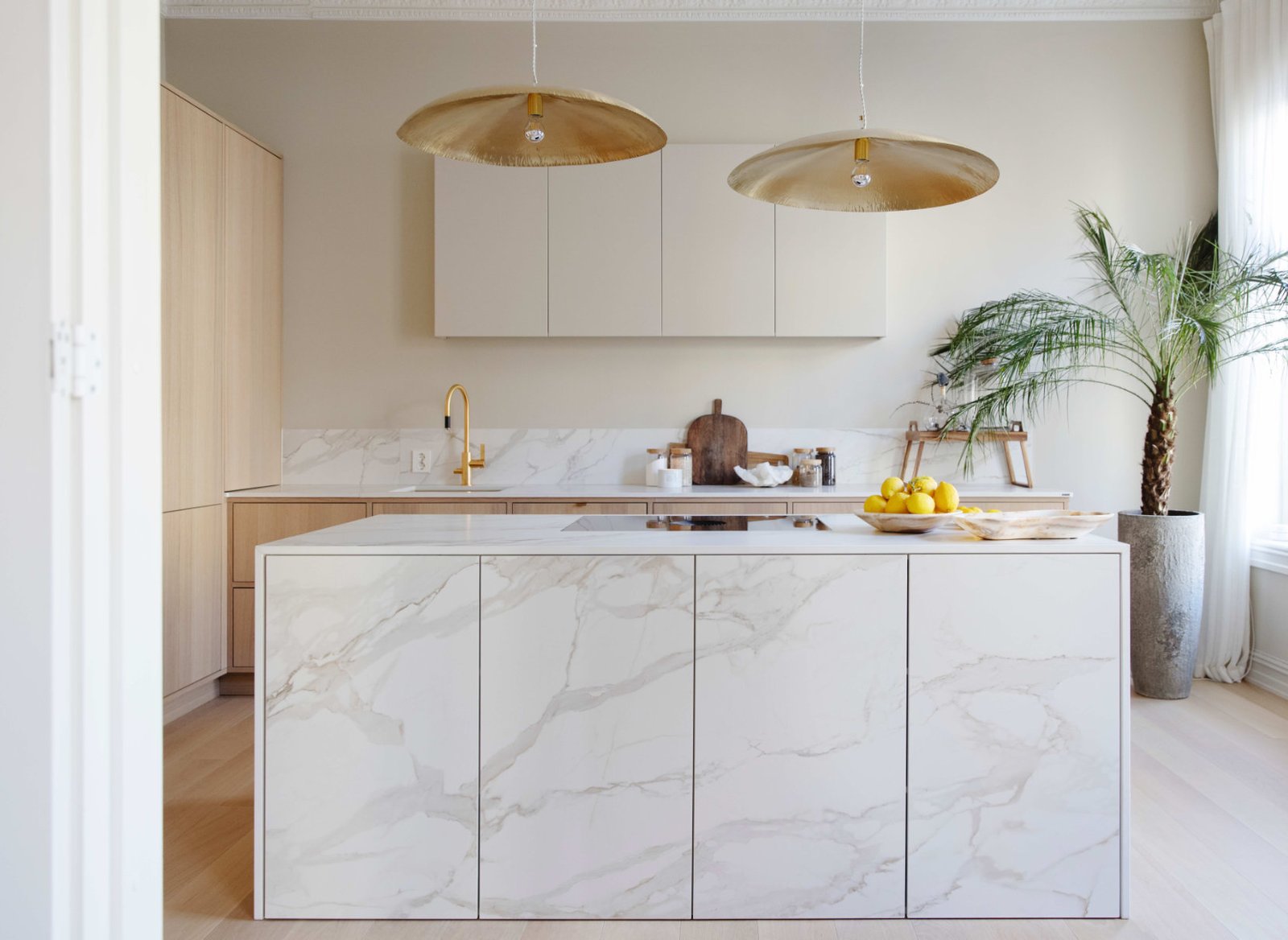 Cucina contemporanea con isola e superfici chiare in Dekton